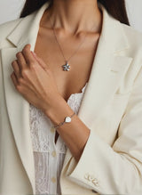 woman wearing silver flower urn necklace for cremains ashes keepsake