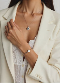 woman wearing silver flower urn necklace for cremains ashes keepsake